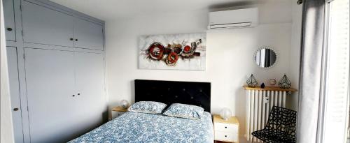 a bedroom with a bed and a picture on the wall at PLEIN SUD Terrasse Panoramique Climatisation Garage Netflix in Lyon