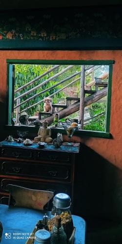 a window in a room with a table in front of it at Sitio Alecrim Gastronomia e Hospedaria in Alagoa