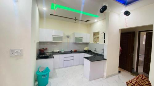 a kitchen with white cabinets and a green light at SBV Homes in Kharar