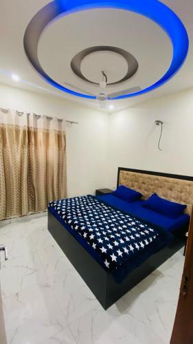a room with a bed with a blue and white ceiling at SBV Homes in Kharar