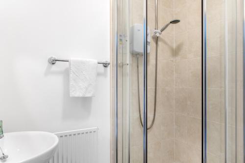 uma casa de banho com um chuveiro e um lavatório. em Spacious 2 bedroom apartment opposite QMC Hospital em Nottingham