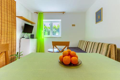 un tazón de naranjas en una mesa en una habitación en Apartments Filipovic, 3 min walk to the beach en Split