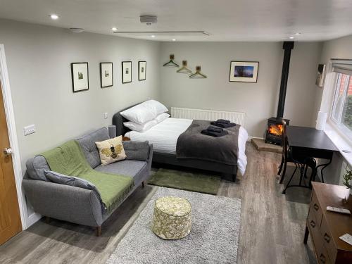 a bedroom with a bed and a couch and a piano at SPALDING - Self Contained Studio Double - An extra single bed can be provided in Lincolnshire