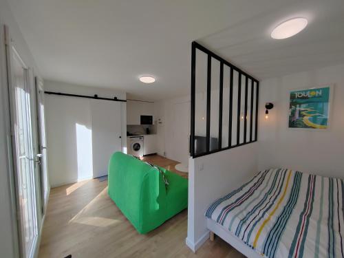 Cet appartement comprend une chambre avec un lit vert et une cuisine. dans l'établissement T1 avec grande terrasse, hypercentre ,climatise, à Toulon
