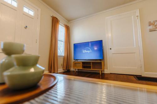 a living room with a television and a table at Historic Revival King Bed Liberty Bowl Memphis 893 in Memphis