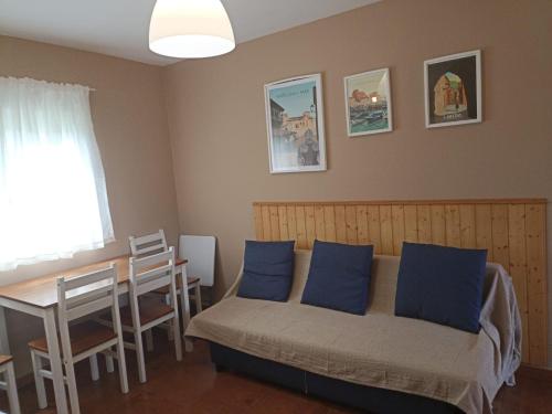 Un dormitorio con una cama con almohadas azules y una mesa. en Apartamentos Guadalupe en Tagle
