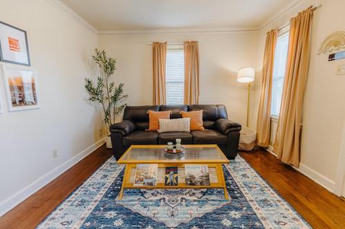a living room with a leather couch and a coffee table at Historic Revival King Bed Liberty Bowl Memphis 893 in Memphis