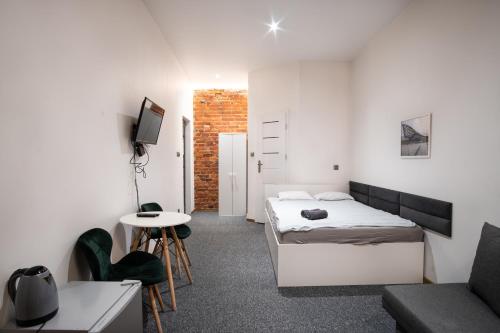 a bedroom with a bed and a table and a couch at Revolution Aparts - Rewolucji 27 in Łódź