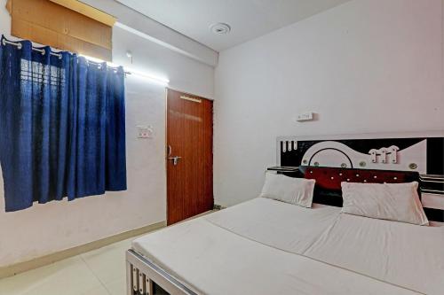 1 dormitorio con cama y cortina azul en OYO Hotel Surya Palace, en Kushinagar