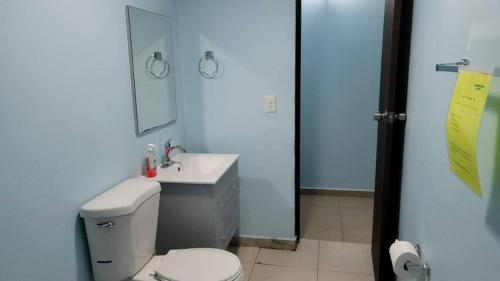 a bathroom with a toilet and a sink and a mirror at Remodeled & Very Cozy sleeps 12 near Casa Bacardi, Center Unit in Catano