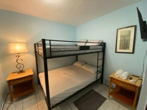 a bedroom with two bunk beds and a lamp at Remodeled & Very Cozy sleeps 12 near Casa Bacardi, Center Unit in Catano