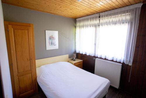 a small bedroom with a white bed and a window at Azureva Bussang in Bussang