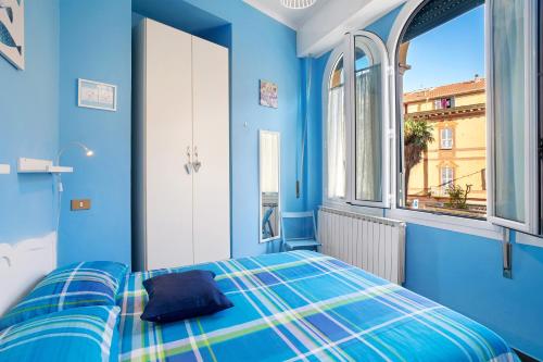 a blue room with a bed and a window at Casa vacanza Teresita 300mt Mare in Imperia