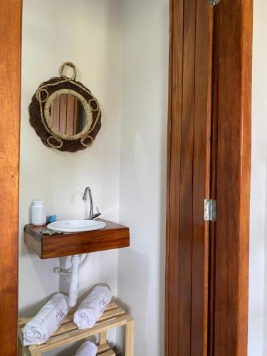 a bathroom with a sink and a mirror at Chalé Entre as Pedras in Serra de São Bento