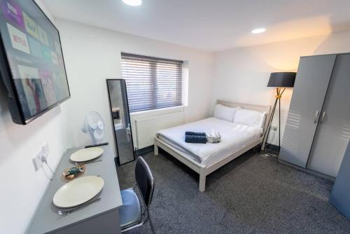 a bedroom with a bed and a desk with a mirror at Captivating 1-Bed studio in Birmingham in Birmingham