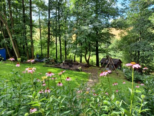 a garden with pink flowers and a gazebo at Trzy Strumyki in Kąty Bystrzyckie