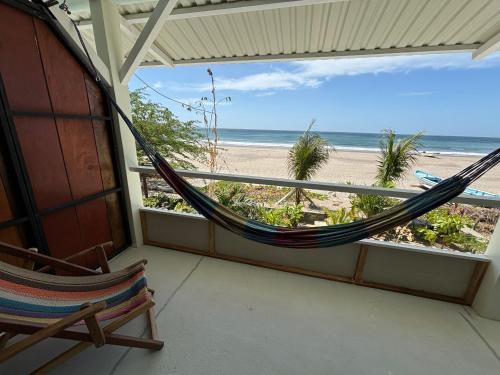 a hammock on a balcony overlooking the beach at Stella Mar Oceanfront Hotel in Popoyo