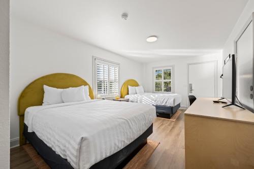 a bedroom with two beds and a television in it at Charleston Creekside Inn in Charleston