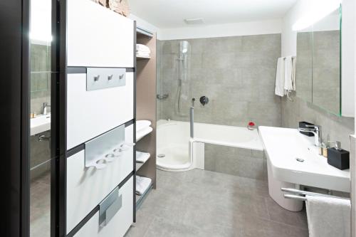 ein Badezimmer mit einem Waschbecken, einer Badewanne und einem WC in der Unterkunft Exklusive 2,5 Zimmer Wohnung in Eschenz