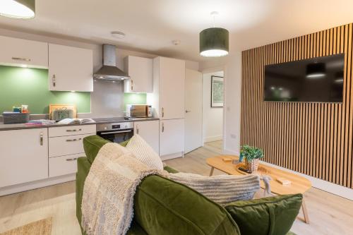 a kitchen and living room with a green couch and a table at Beautiful apartment in city centre in Southampton