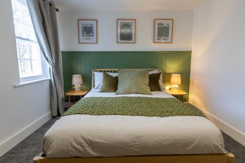 a bedroom with a large bed with green walls and two lamps at Beautiful apartment in city centre in Southampton
