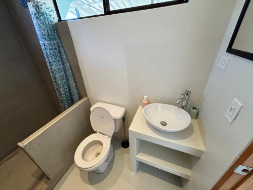 a small bathroom with a toilet and a sink at Stella Mar Oceanfront Hotel in Popoyo