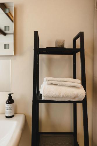 a black towel rack with towels on it in a bathroom at Epokgården in Öregrund