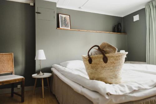 a bedroom with a bed with a basket on it at Epokgården in Öregrund
