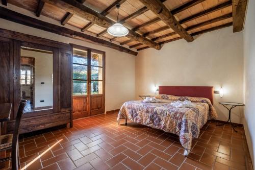 - une chambre avec un lit et une grande fenêtre dans l'établissement Genziana, à Arcidosso