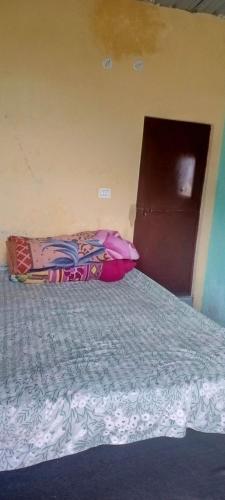 Bett in einem Zimmer mit einer Tür und einem Bett sidx sidx in der Unterkunft Shri Ram Homestay in Bangīna
