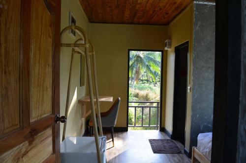 a room with a desk and a door with a window at Phangnga Save House - เซฟเฮาส์พังงา in Phangnga