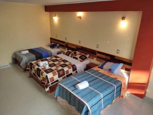 um quarto com três camas num quarto em HOSPEDAJE LA CABAÑA em San Ramón