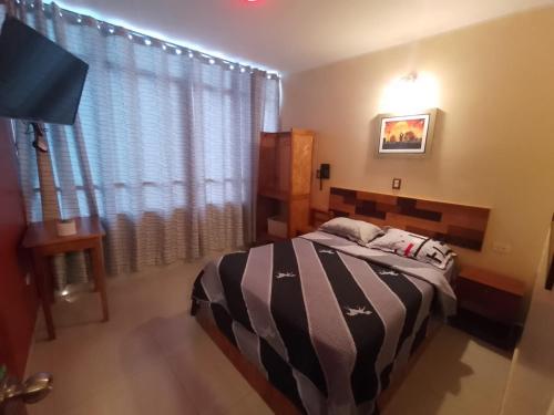 - une chambre avec un lit et une grande fenêtre dans l'établissement HOSPEDAJE LA CABAÑA, à San Ramón