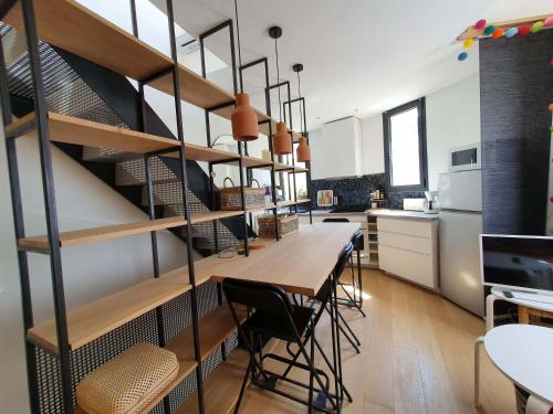 a kitchen and dining room with a long table and chairs at L'Exquishette de Lourmarin, un nid sur les toits. in Lourmarin