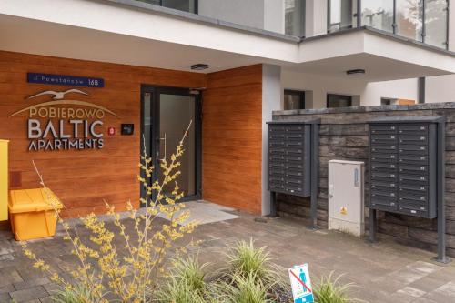 a building with black doors and a sign that reads apartments at Pobierowo Beach Baltic Apartment with Pool by Noclegi Renters in Pobierowo