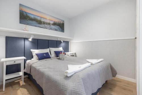 a bedroom with a large bed with two towels on it at Pobierowo Beach Baltic Apartments by Renters in Pobierowo