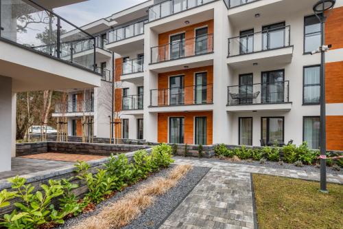an apartment building with a courtyard with plants at Pobierowo Beach Baltic Apartment with Pool by Noclegi Renters in Pobierowo