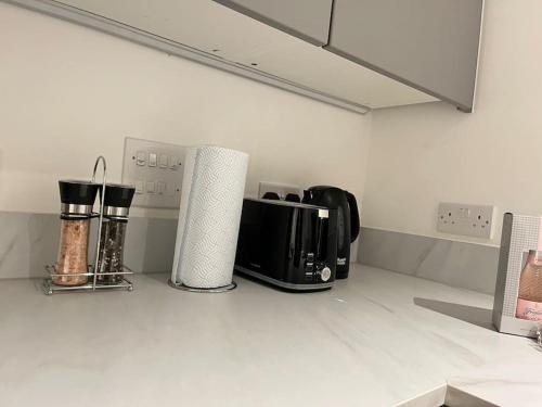 a kitchen counter with a toaster and a microwave at 2bed on Elizabeth line-5mins to Excel Custom House in London