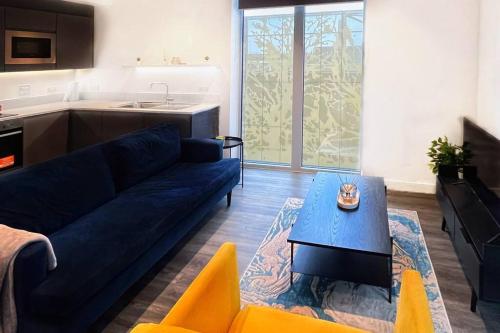 un soggiorno con divano blu e tavolo di 2bed on Elizabeth line-5mins to Excel Custom House a Londra