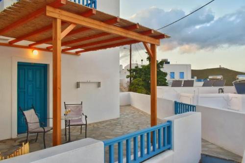 a balcony with chairs and a blue door on a house at Castelli Studios in Astypalaia