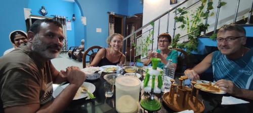 a group of people sitting at a table eating at Munnar Village Homes in Munnar
