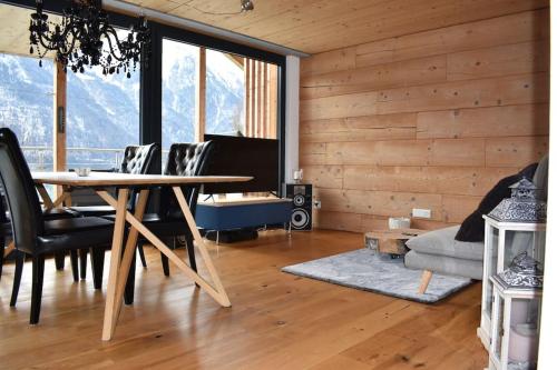 a living room with a table and chairs and a couch at Lina - Lakeview Living near Interlaken in Niederried