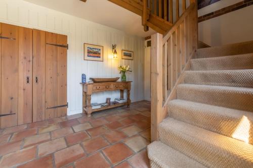 aoyer with stairs and a table and a door at Oyster Barn in Titchwell