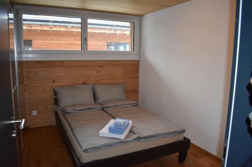 a small bedroom with a bed with a window at Lina - Lakeview Living near Interlaken in Niederried