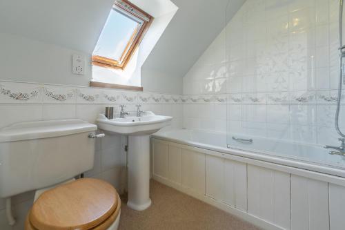 a bathroom with a toilet and a sink and a bath tub at Oyster Barn in Titchwell