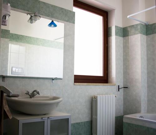 e bagno con lavandino, specchio e vasca. di Aliseo B&B a Lecce