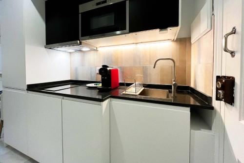 una piccola cucina con lavandino e un apparecchio rosso di Genteel Home Baños a Siviglia