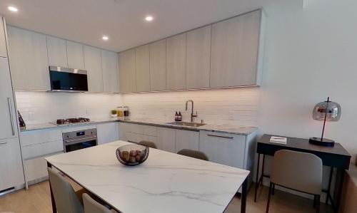 a kitchen with a table with a bowl of fruit on it at Level Long Beach - East Village in Long Beach