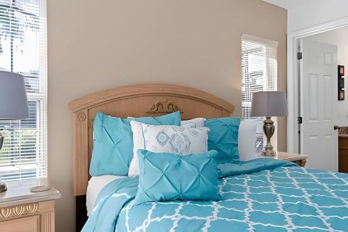 a bedroom with a blue bed with pillows at Quiet house with pool on a Top golf course in Haines City