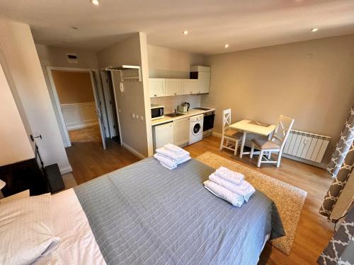 a bedroom with a bed and a kitchen with a table at Predela 2 Aparthotel in Bansko